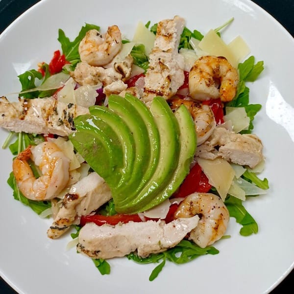 LouCas Italian salad with grilled chicken, shrimp, avocado, arugula, roasted peppers, and parmesan.