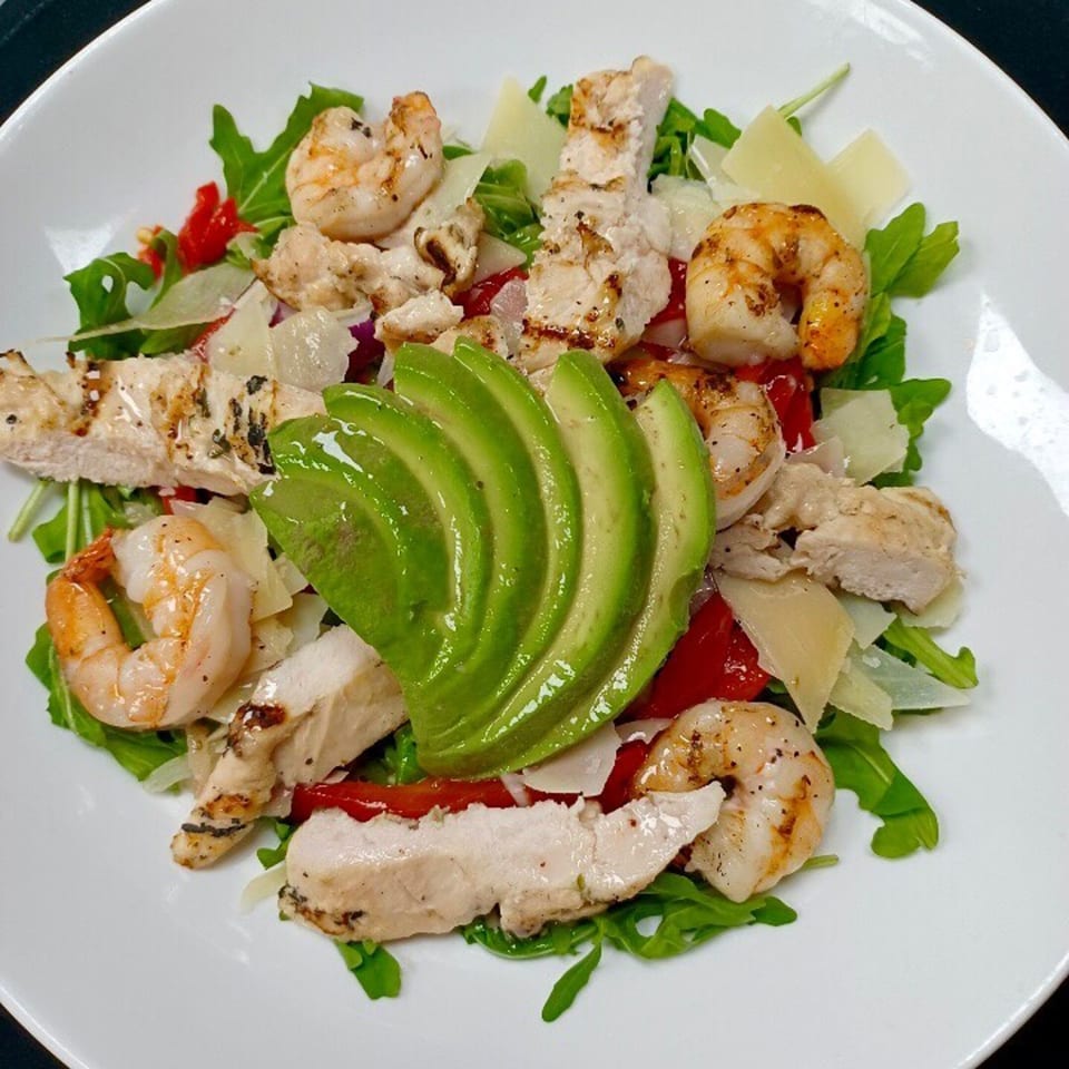 LouCas Italian salad with grilled chicken, shrimp, avocado, arugula, roasted peppers, and parmesan.