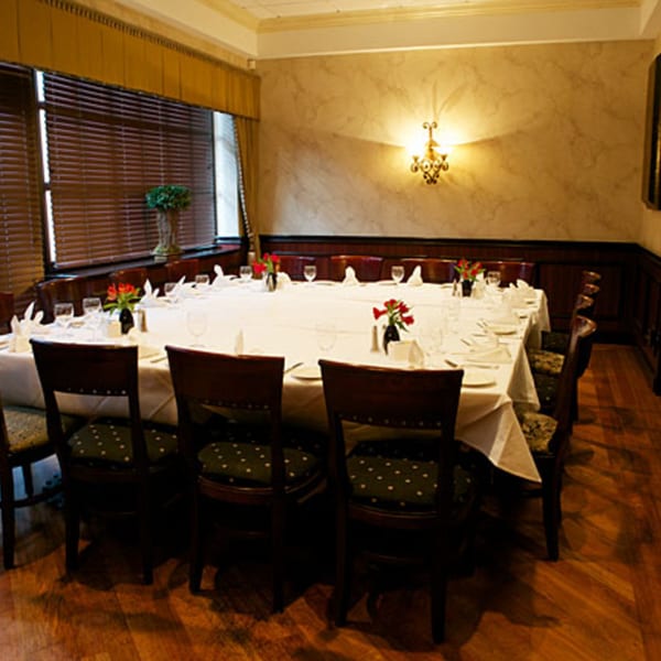 LouCas private dining room with a large set table, elegant decor, and warm lighting.